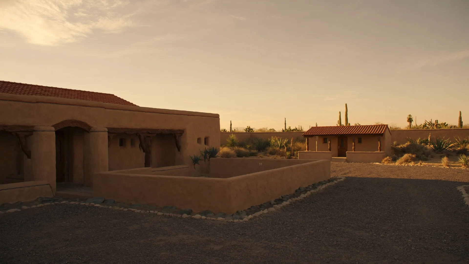 A Southwest-style casita with a courtyard connection to the main house on the left, and a fully detached guest house cottage on the right, under warm desert light
